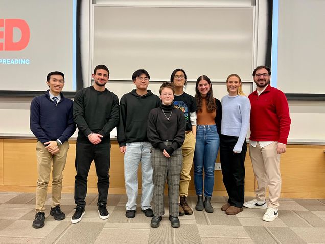 eight BU students standing in front of a big screen