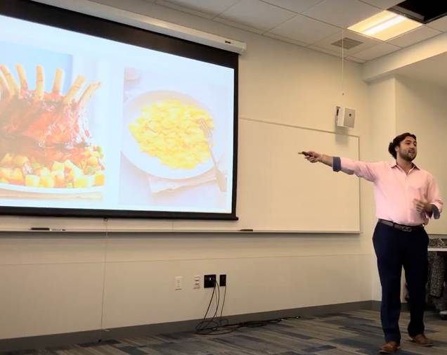 student delivering a speech in front of a whiteboard